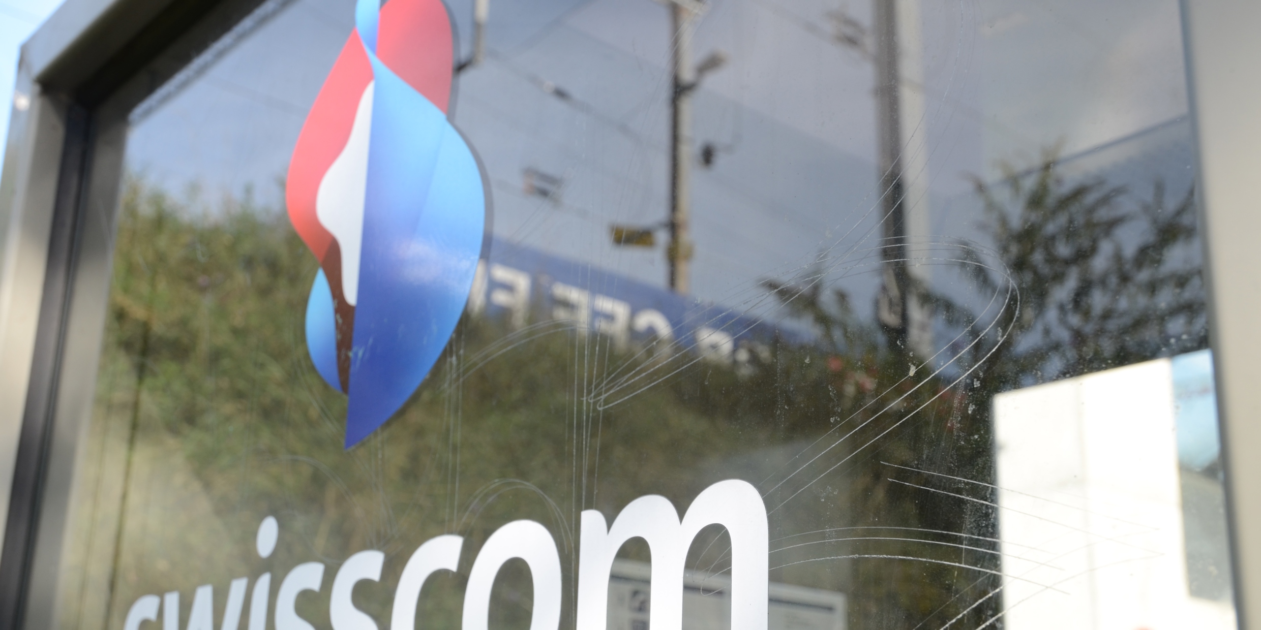 Das Logo der Swisscom an einer glas Fassade